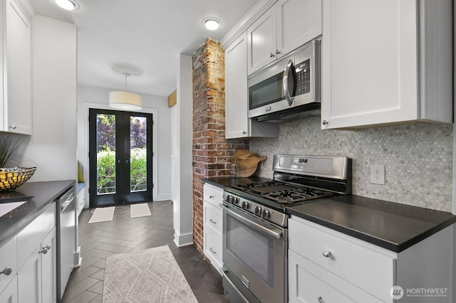 kitchen with appliances with stainless steel finishes, dark countertops, and backsplash