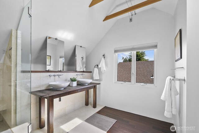 bathroom with a sink, wood-type flooring, and a tile shower