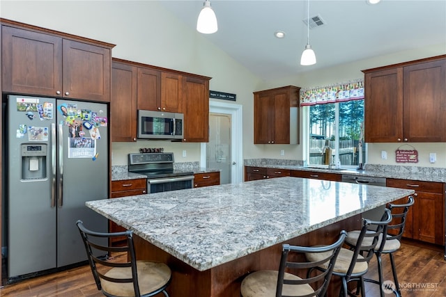 1109 Walker St, Port Angeles, WA 98363 - kitchen featuring stainless steel appliances, lofted ceiling, a sink, dark wood-style floors, and a breakfast bar area