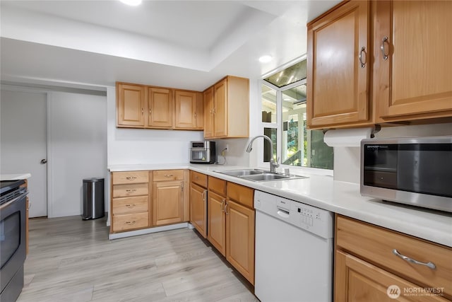 7412 E E St, Tacoma, WA 98404 - kitchen featuring stainless steel appliances, light countertops, a raised ceiling, and light wood-style flooring