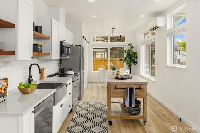 kitchen with open shelves, appliances with stainless steel finishes, a wall mounted AC, white cabinets, and recessed lighting