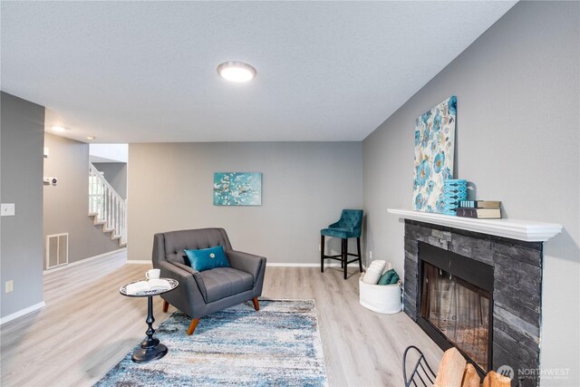16016 NE 41st St, Vancouver, WA 98628 - living area featuring wood finished floors, a stone fireplace, stairway, and baseboards