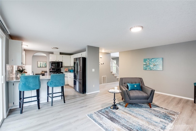 16016 NE 41st St, Vancouver, WA 98628 - living area with arched walkways, light wood-type flooring, stairway, and baseboards
