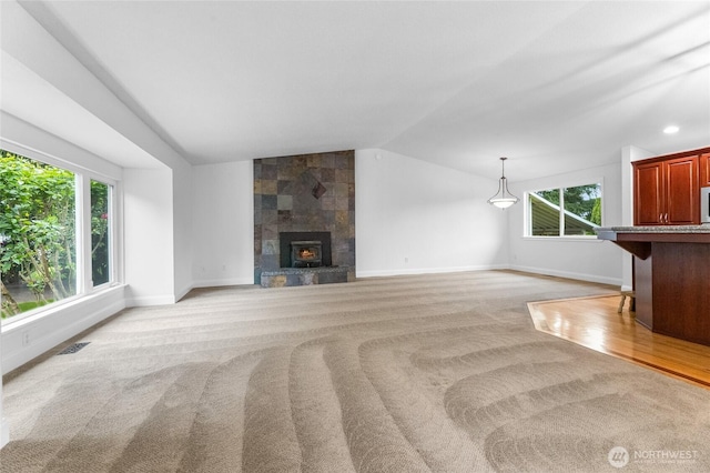 16912 49th St E, Lake Tapps, WA 98391 - unfurnished living room featuring lofted ceiling, baseboards, plenty of natural light, and light colored carpet