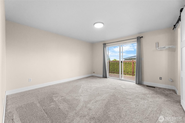 16912 49th St E, Lake Tapps, WA 98391 - carpeted empty room featuring a barn door and baseboards
