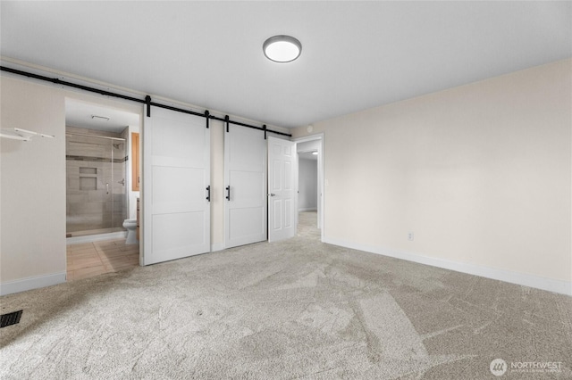 16912 49th St E, Lake Tapps, WA 98391 - unfurnished bedroom with carpet, baseboards, ensuite bath, and a barn door