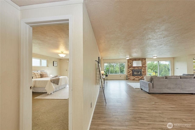 hall featuring wood finished floors, a textured ceiling, and baseboards