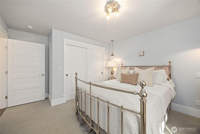 bedroom featuring light carpet, baseboards, and a closet