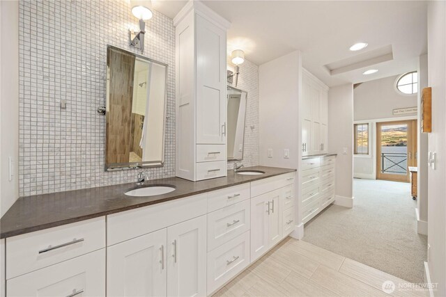 bathroom with double vanity and baseboards