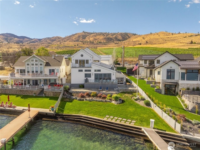 rear view of property featuring a water and mountain view and fence