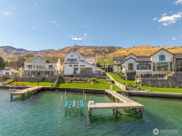 dock area featuring a water and mountain view and boat lift