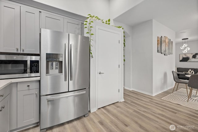 15017 46th Ave SE, Everett, WA 98208 - kitchen featuring stainless steel appliances, gray cabinetry, light wood-style flooring, baseboards, and light countertops