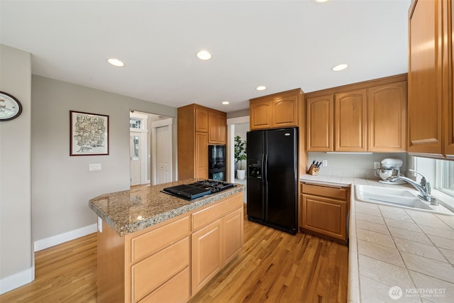 1855 Shanon Ln, Enumclaw, WA 98022 - kitchen with black appliances, a sink, tile counters, light wood-style floors, and a kitchen island