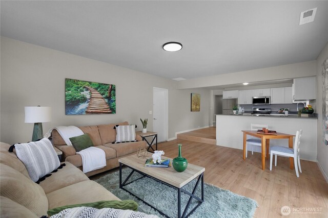 living area with light wood-style floors and baseboards