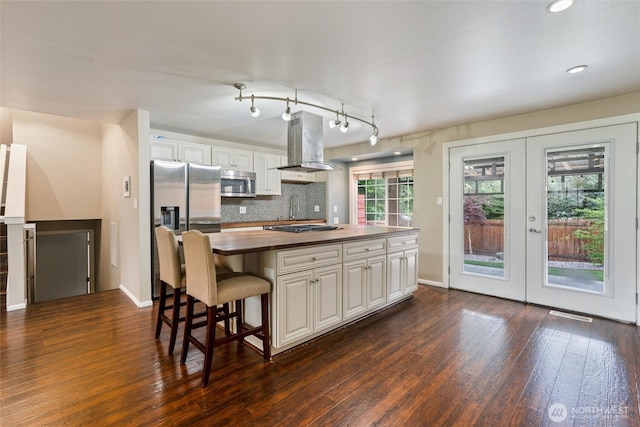 3620 Westminster Dr SE, Port Orchard, WA 98366 - kitchen with stainless steel appliances, island exhaust hood, dark wood finished floors, a kitchen island, and french doors