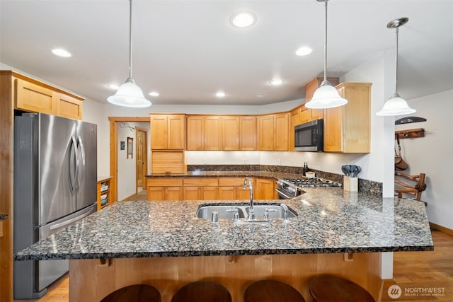 39800 224th Ave SE, Enumclaw, WA 98022 - kitchen featuring stainless steel appliances, a sink, a peninsula, a kitchen bar, and light wood-style floors
