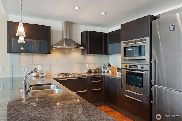 737 Olive Way Unit 2703, Seattle, WA 98101 - kitchen with stainless steel appliances, wall chimney range hood, dark stone countertops, tasteful backsplash, and recessed lighting