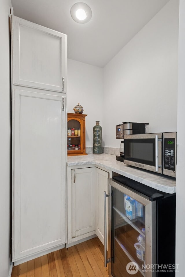 15715 249th Ave SE, Issaquah, WA 98027 - bar area featuring beverage cooler, stainless steel microwave, and light wood-style floors