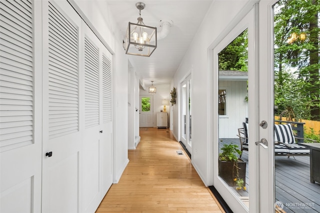 15715 249th Ave SE, Issaquah, WA 98027 - hallway featuring french doors, light wood-style floors, and a chandelier
