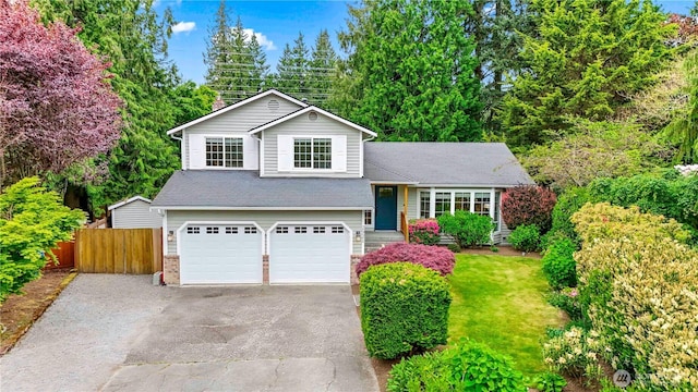 split level home with fence, driveway, an attached garage, roof with shingles, and a chimney