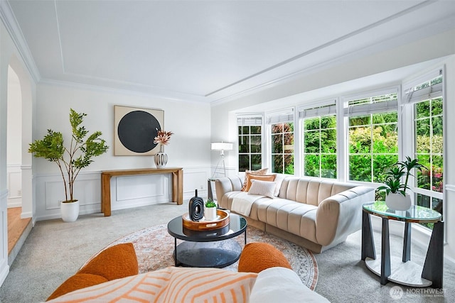 living area with carpet floors, crown molding, a decorative wall, and a wainscoted wall