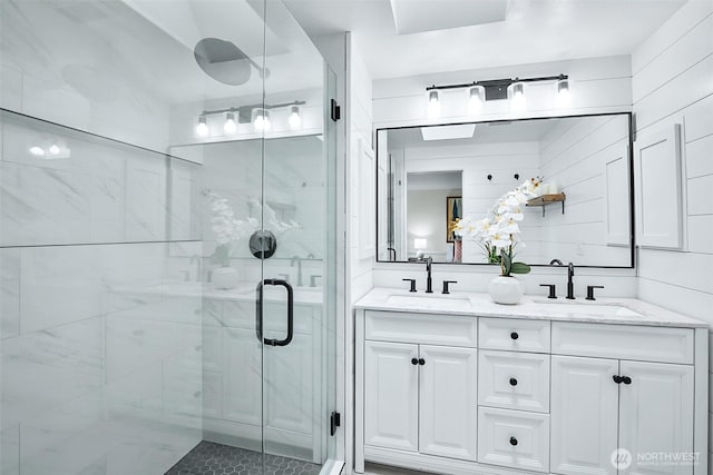 bathroom featuring a shower stall and double vanity