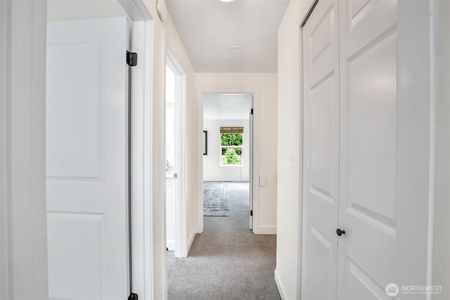 hallway with carpet and baseboards