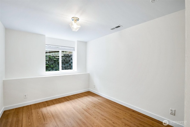 unfurnished room with wood finished floors and baseboards