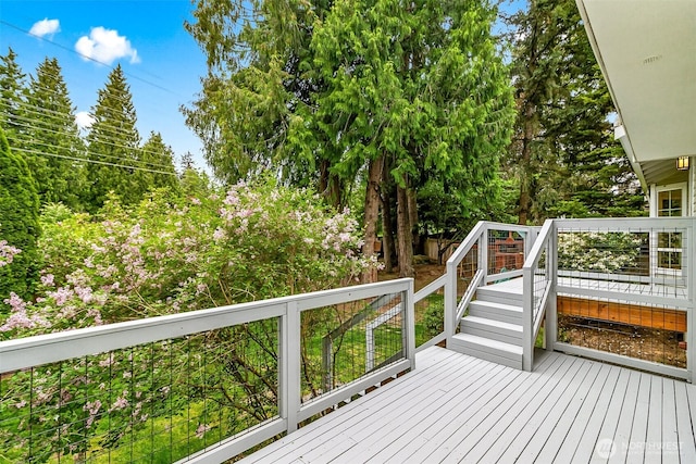 wooden terrace featuring view of wooded area