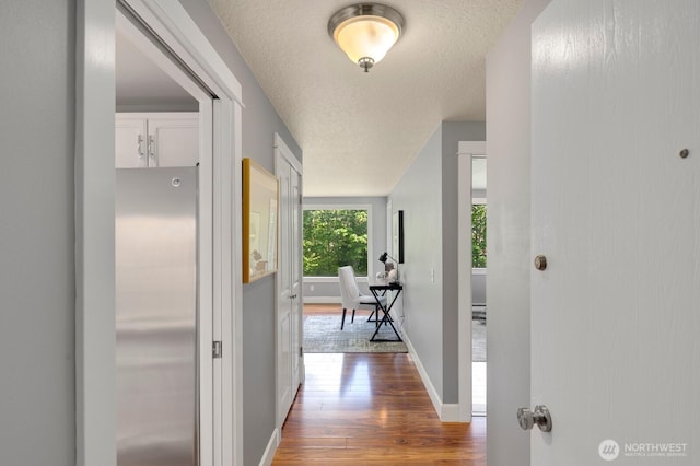 610 Aloha St Unit 303, Seattle, WA 98109 - hall featuring dark wood finished floors, a textured ceiling, and baseboards