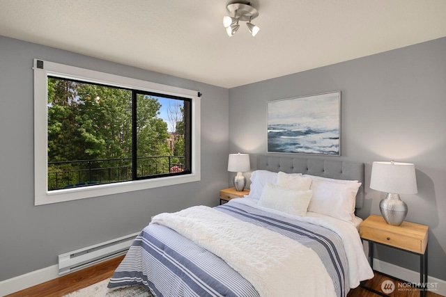 610 Aloha St Unit 303, Seattle, WA 98109 - bedroom with baseboard heating, wood finished floors, and baseboards