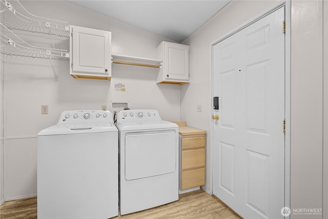 laundry room with separate washer and dryer, cabinet space, and light wood-type flooring
