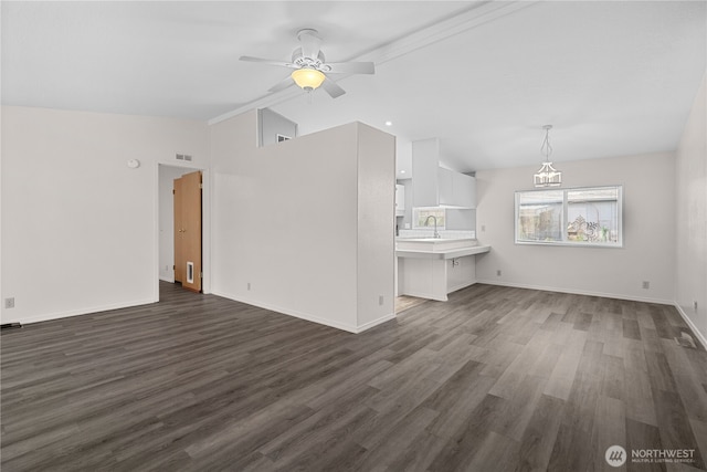 unfurnished living room with lofted ceiling, a ceiling fan, dark wood-style floors, a sink, and baseboards
