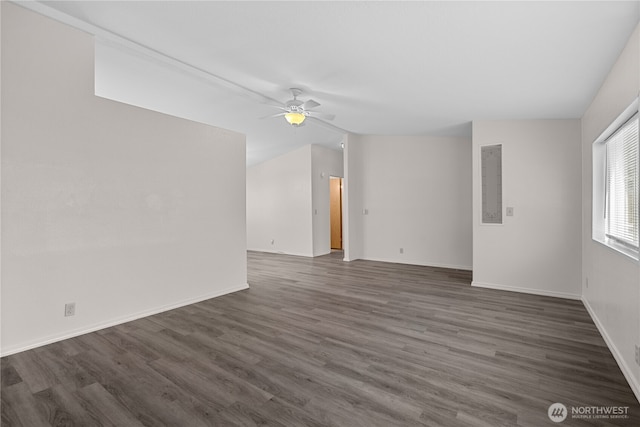 empty room featuring ceiling fan, dark wood finished floors, and baseboards