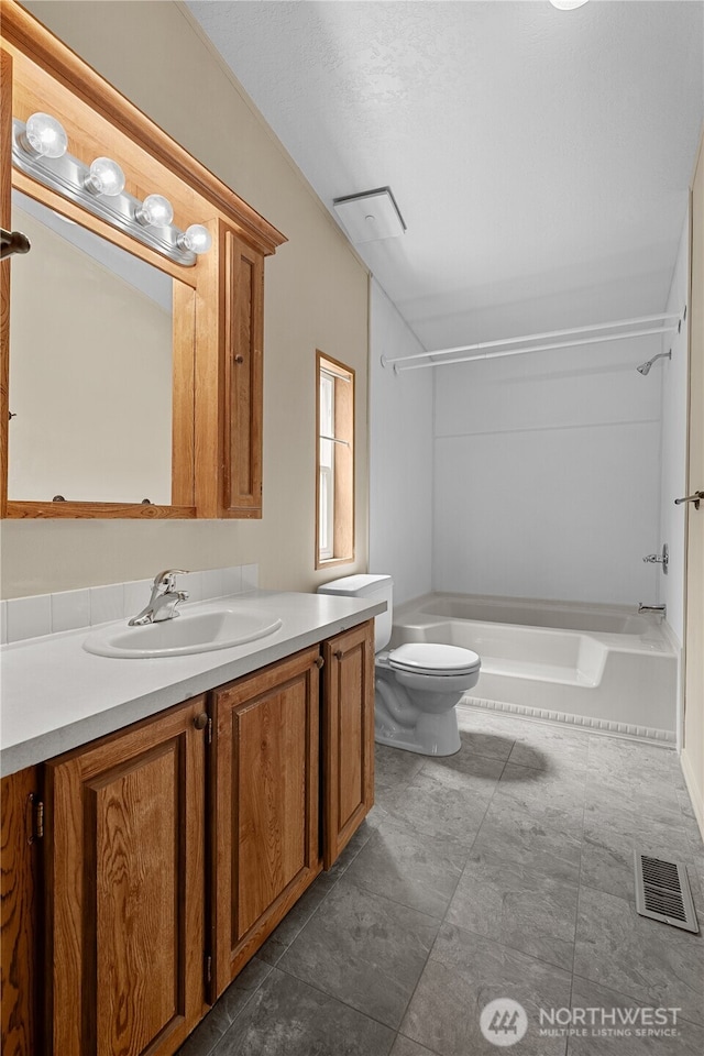 bathroom with toilet, vanity, and  shower combination