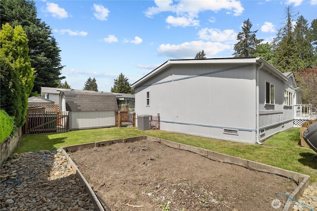 back of house with a garden, central AC unit, a shed, an outdoor structure, and crawl space