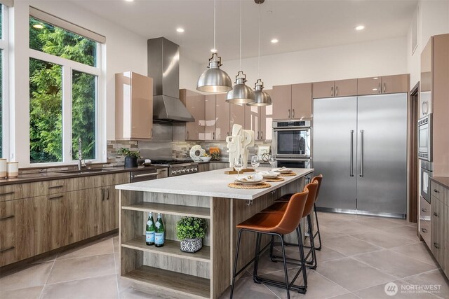 8553 NE Juanita Dr, Kirkland, WA 98034 - kitchen with built in appliances, wall chimney exhaust hood, tasteful backsplash, open shelves, and a kitchen bar