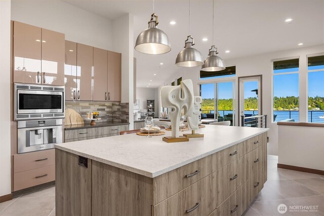 8553 NE Juanita Dr, Kirkland, WA 98034 - kitchen featuring appliances with stainless steel finishes, a center island, modern cabinets, light tile patterned floors, and decorative backsplash