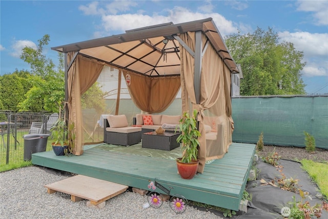 view of patio with fence, a gazebo, a deck, and an outdoor living space
