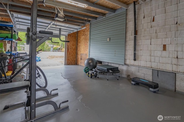 garage featuring a garage door opener and concrete block wall