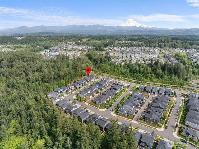 13127 184th Ave E, Bonney Lake, WA 98391 - aerial overview of property's location with a heavily wooded area, a mountainous background, and nearby suburban area