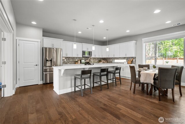 13127 184th Ave E, Bonney Lake, WA 98391 - kitchen with appliances with stainless steel finishes, light countertops, tasteful backsplash, dark wood-style floors, and white cabinets