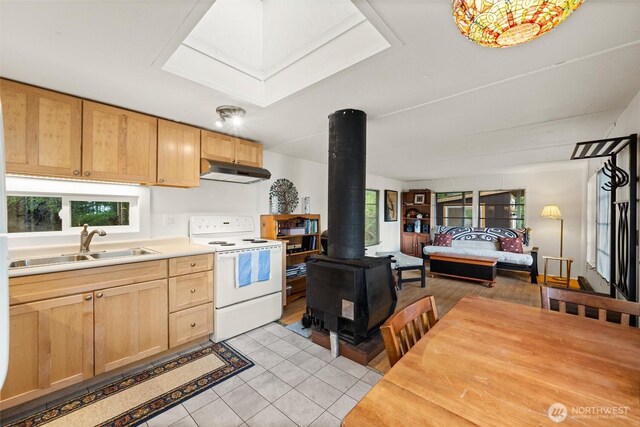 1059 Island Dr, Lummi Island, WA 98262 - kitchen featuring white electric stove, a wood stove, under cabinet range hood, a sink, and plenty of natural light