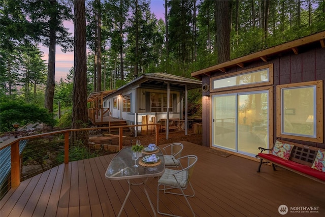 1059 Island Dr, Lummi Island, WA 98262 - deck at dusk with outdoor dining area and an outbuilding
