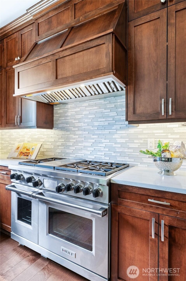 9827 NE 20th St, Bellevue, WA 98004 - kitchen with range with two ovens, custom range hood, light countertops, and tasteful backsplash