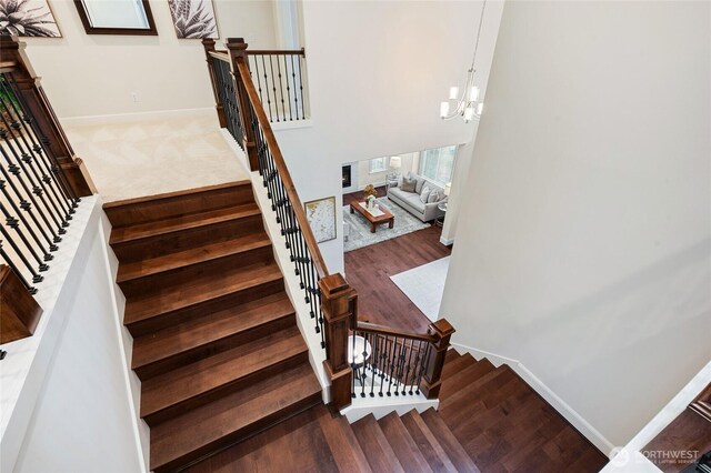 9827 NE 20th St, Bellevue, WA 98004 - staircase with wood finished floors, a chandelier, and baseboards