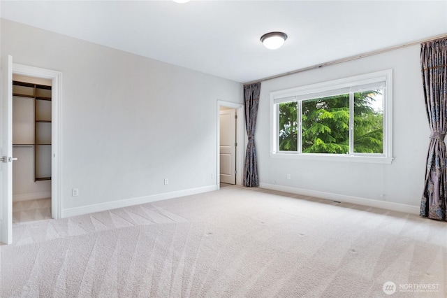 9827 NE 20th St, Bellevue, WA 98004 - unfurnished bedroom with baseboards, carpet flooring, and a walk in closet
