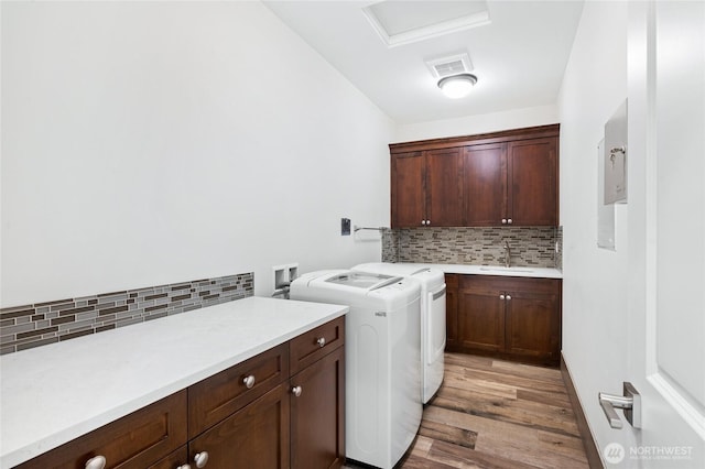 9827 NE 20th St, Bellevue, WA 98004 - clothes washing area with cabinet space, washing machine and clothes dryer, light wood-type flooring, and attic access
