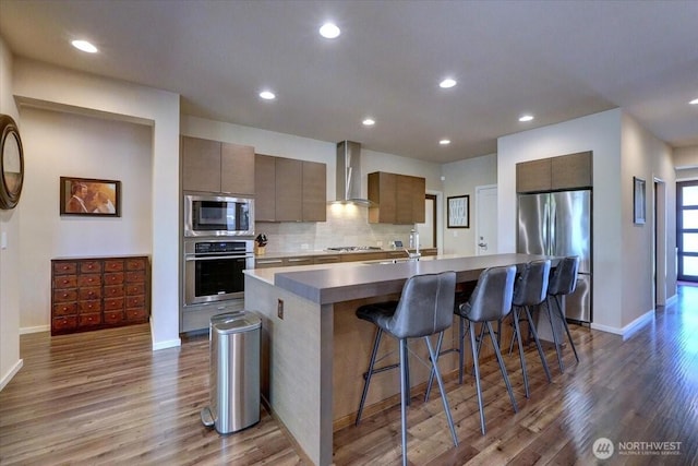 13406 SE 262nd St, Kent, WA 98042 - kitchen with appliances with stainless steel finishes, wall chimney exhaust hood, dark wood finished floors, a breakfast bar, and baseboards