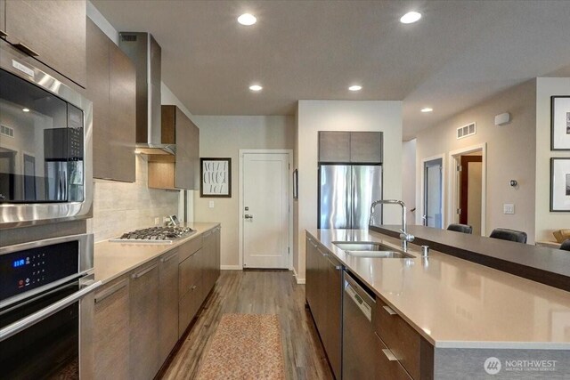 13406 SE 262nd St, Kent, WA 98042 - kitchen featuring appliances with stainless steel finishes, a sink, wall chimney exhaust hood, modern cabinets, and dark wood finished floors